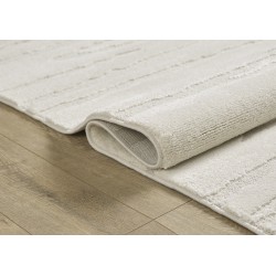 Modern cream-colored rug with linear relief and layered texture